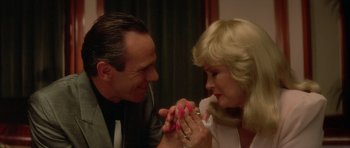 Movie still from “Wild at Heart” (1990), directed by David Lynch – A man and a woman are holding hands and looking at one another; Close Up shot, High angle