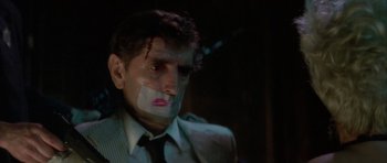 Movie still from “Wild at Heart” (1990), directed by David Lynch – A man with a bandage on his face and a bandage on his face; Close Up shot, Low angle