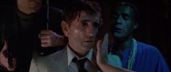 Movie still from “Wild at Heart” (1990), directed by David Lynch – A man with blood on his face is being shaved; Close Up shot, Over the shoulder angle