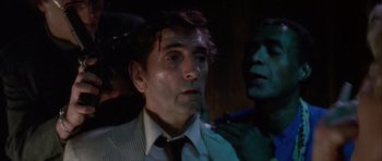 Movie still from “Wild at Heart” (1990), directed by David Lynch – A person wearing a suit and tie; Close Up shot, Low angle