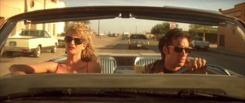 Movie still from “Wild at Heart” (1990), directed by David Lynch – A man and a woman sitting in the back of a car; Medium shot, Low angle