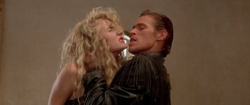 Movie still from “Wild at Heart” (1990), directed by David Lynch – A man and a woman in leather jackets kissing; Close Up shot, Low angle