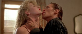 Movie still from “Wild at Heart” (1990), directed by David Lynch – A man and a woman are kissing in a room; Close Up shot, Low angle