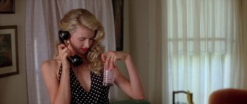Movie still from “Wild at Heart” (1990), directed by David Lynch – A beautiful blonde woman holding a cup and wearing headphones; Close Up shot, High angle