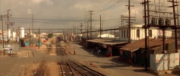 Movie still from “Wild at Heart” (1990), directed by David Lynch – A train station with a train on the tracks; Extreme Wide shot, High angle