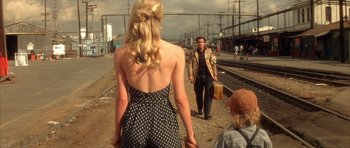 Movie still from “Wild at Heart” (1990), directed by David Lynch – A man and a woman walking down a train track; Medium shot, Over the shoulder angle