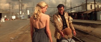 Movie still from “Wild at Heart” (1990), directed by David Lynch – A man and a woman standing next to each other; Medium shot, Over the shoulder angle