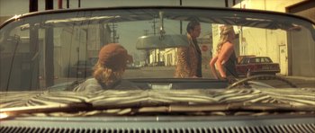 Movie still from “Wild at Heart” (1990), directed by David Lynch – A man and a woman in the back of a car; Wide shot, Over the shoulder angle