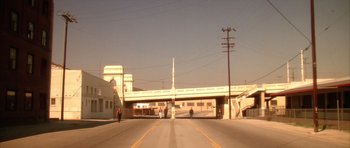 Movie still from “Wild at Heart” (1990), directed by David Lynch – People are crossing the street on a sunny day; Extreme Wide shot, High angle