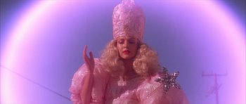 Movie still from “Wild at Heart” (1990), directed by David Lynch – A woman dressed as the fairy godmother from the movie the wizard of oz; Medium shot, Low angle