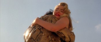 Movie still from “Wild at Heart” (1990), directed by David Lynch – A woman is hugging a large snake in the air; Close Up shot, Low angle
