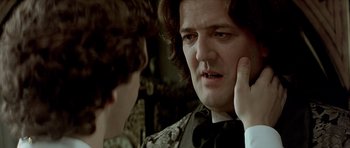 Movie still from “Wilde” (1997), directed by Brian Gilbert – A man in a suit and tie looking at another man in a suit and tie; Close Up shot, Over the shoulder angle