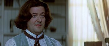 Movie still from “Wilde” (1997), directed by Brian Gilbert – A person wearing a shirt and a tie; Close Up shot, Over the shoulder angle