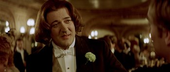 Movie still from “Wilde” (1997), directed by Brian Gilbert – A person wearing a suit and a bow tie; Close Up shot, Over the shoulder angle