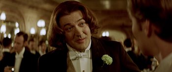 Movie still from “Wilde” (1997), directed by Brian Gilbert – A person wearing a suit and bow tie; Close Up shot, Over the shoulder angle
