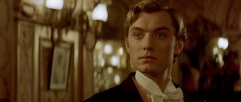 Movie still from “Wilde” (1997), directed by Brian Gilbert – A man in a suit and tie looking at the camera; Close Up shot, Low angle