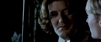 Movie still from “Wilde” (1997), directed by Brian Gilbert – A person wearing a suit and tie; Close Up shot, Low angle