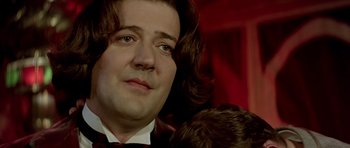 Movie still from “Wilde” (1997), directed by Brian Gilbert – A person wearing a suit and tie; Close Up shot, Over the shoulder angle