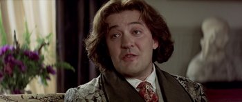 Movie still from “Wilde” (1997), directed by Brian Gilbert – A person wearing a suit and tie; Close Up shot, Over the shoulder angle