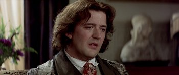 Movie still from “Wilde” (1997), directed by Brian Gilbert – A person wearing a suit and a tie; Close Up shot, Over the shoulder angle
