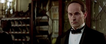 Movie still from “Wilde” (1997), directed by Brian Gilbert – A person wearing a suit and tie; Close Up shot, Low angle