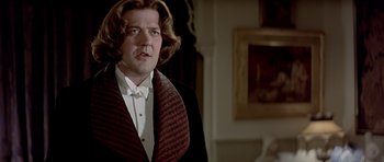 Movie still from “Wilde” (1997), directed by Brian Gilbert – A person wearing a suit and tie; Close Up shot, Over the shoulder angle