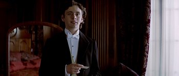 Movie still from “Wilde” (1997), directed by Brian Gilbert – A young man in a tuxedo holding a white paper; Close Up shot, Low angle