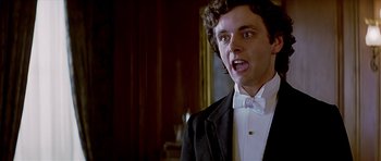 Movie still from “Wilde” (1997), directed by Brian Gilbert – A man wearing a tuxedo and a bow tie in front of a mirror; Close Up shot, Low angle