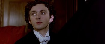 Movie still from “Wilde” (1997), directed by Brian Gilbert – A person wearing a suit and bow tie; Close Up shot, Low angle