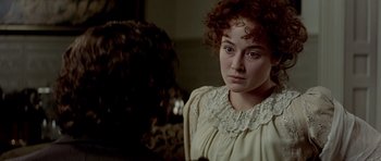 Movie still from “Wilde” (1997), directed by Brian Gilbert – A woman with curly red hair wearing a white dress; Close Up shot, Over the shoulder angle