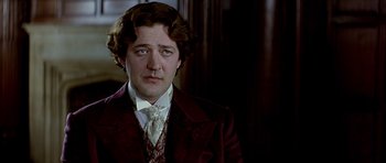 Movie still from “Wilde” (1997), directed by Brian Gilbert – A person wearing a suit and tie; Close Up shot, Over the shoulder angle