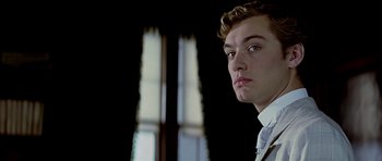 Movie still from “Wilde” (1997), directed by Brian Gilbert – A young man in a white shirt is looking at the camera; Close Up shot, Low angle