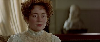 Movie still from “Wilde” (1997), directed by Brian Gilbert – A person with curly hair wearing a dress; Close Up shot, Over the shoulder angle