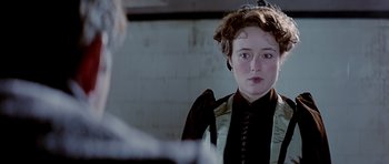 Movie still from “Wilde” (1997), directed by Brian Gilbert – A woman in a black dress and a white shirt; Close Up shot, Over the shoulder angle