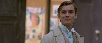 Movie still from “Wilde” (1997), directed by Brian Gilbert – A man in a suit and tie smiling for the camera; Close Up shot, Low angle