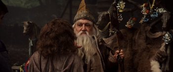 Movie still from “Willow” (1988), directed by Ron Howard – An old man dressed as gandalf with long white beard; Close Up shot, Over the shoulder angle