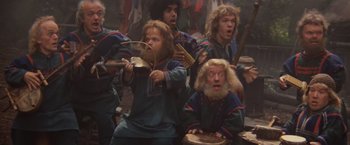 Movie still from “Willow” (1988), directed by Ron Howard – A group of people sitting in a room; Wide shot, High angle