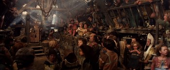 Movie still from “Willow” (1988), directed by Ron Howard – A group of people standing around in a room; Wide shot, High angle