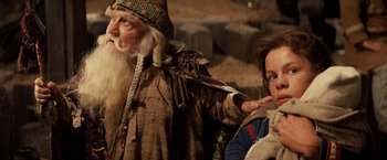 Movie still from “Willow” (1988), directed by Ron Howard – An old man and a young woman standing next to each other; Medium shot, Low angle