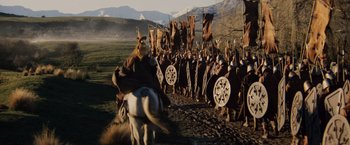 Movie still from “Willow” (1988), directed by Ron Howard – A group of people in medieval garb are gathered in a field; Wide shot, High angle
