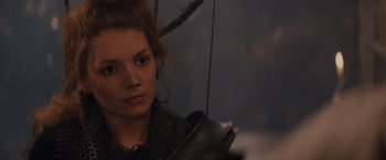 Movie still from “Willow” (1988), directed by Ron Howard – A young woman is looking at the camera while holding a umbrella; Close Up shot, Over the shoulder angle