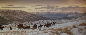 Movie still from “Willow” (1988), directed by Ron Howard – A group of people riding horses on a snowy hill; Extreme Wide shot, Low angle