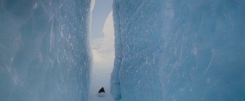 Movie still from “Willow” (1988), directed by Ron Howard – A person skiing down a snow covered slope; Extreme Wide shot, Overhead angle