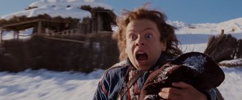 Movie still from “Willow” (1988), directed by Ron Howard – A young man is in the snow with his mouth wide open; Close Up shot, Low angle