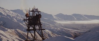 Movie still from “Willow” (1988), directed by Ron Howard – A wooden structure in the middle of a snow covered mountain; Extreme Wide shot, Low angle