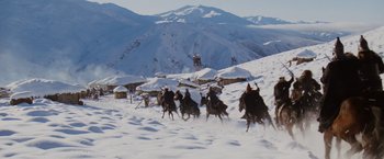 Movie still from “Willow” (1988), directed by Ron Howard – A group of people riding horses through the snow; Extreme Wide shot, High angle