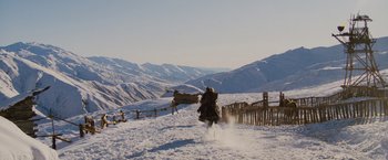 Movie still from “Willow” (1988), directed by Ron Howard – A man riding a sled down a snow covered slope; Extreme Wide shot, Low angle
