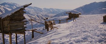 Movie still from “Willow” (1988), directed by Ron Howard – A wooden fence on top of a snow covered slope; Extreme Wide shot, High angle
