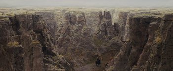 Movie still from “Willow” (1988), directed by Ron Howard – A man on a horse in the middle of a canyon; Extreme Wide shot, High angle