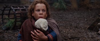 Movie still from “Willow” (1988), directed by Ron Howard – A young boy holding a stuffed animal in his arms; Medium shot, Low angle